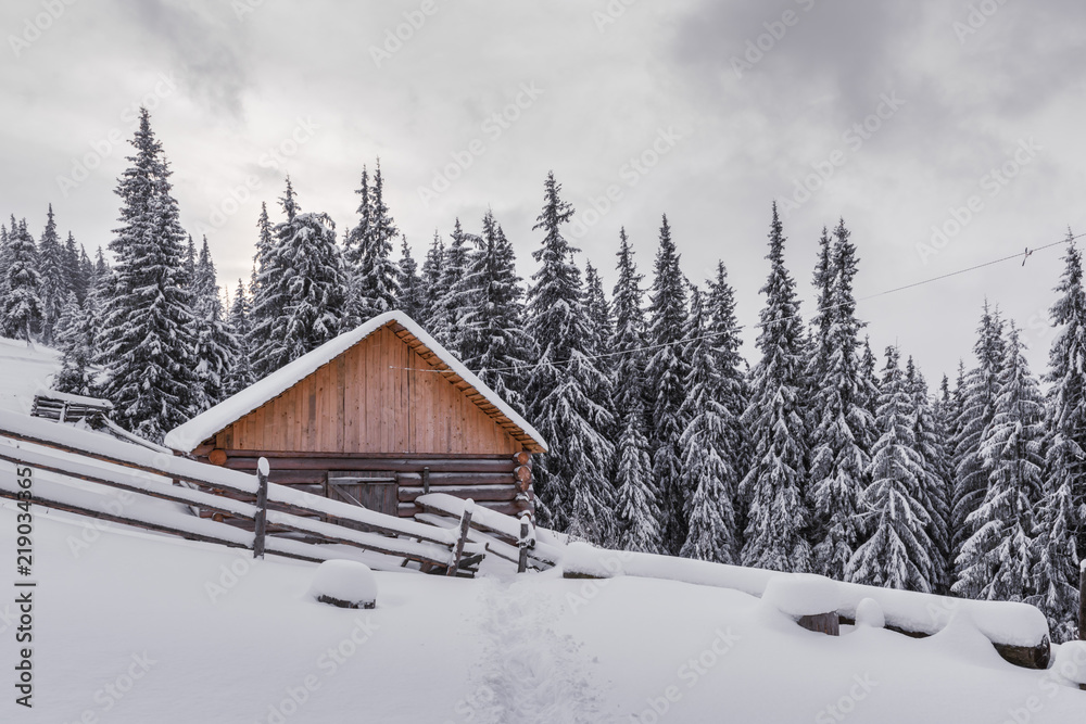 Fantastic winter landscape with wooden house in snowy mountains. Christmas holiday concept. Carpathi