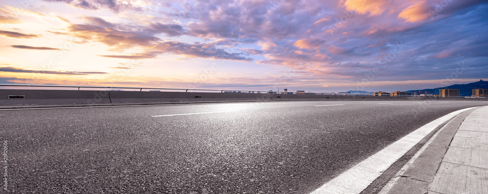 empty asphalt highway street with city skyline