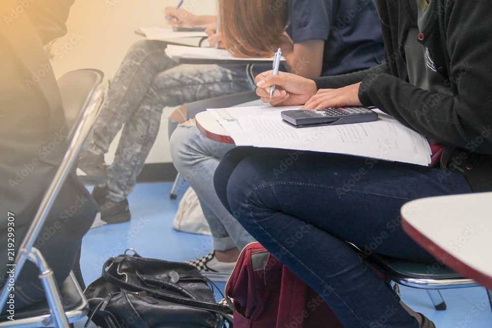 Hands university student holding pen writing /calculator doing examination / study or quiz, test fro