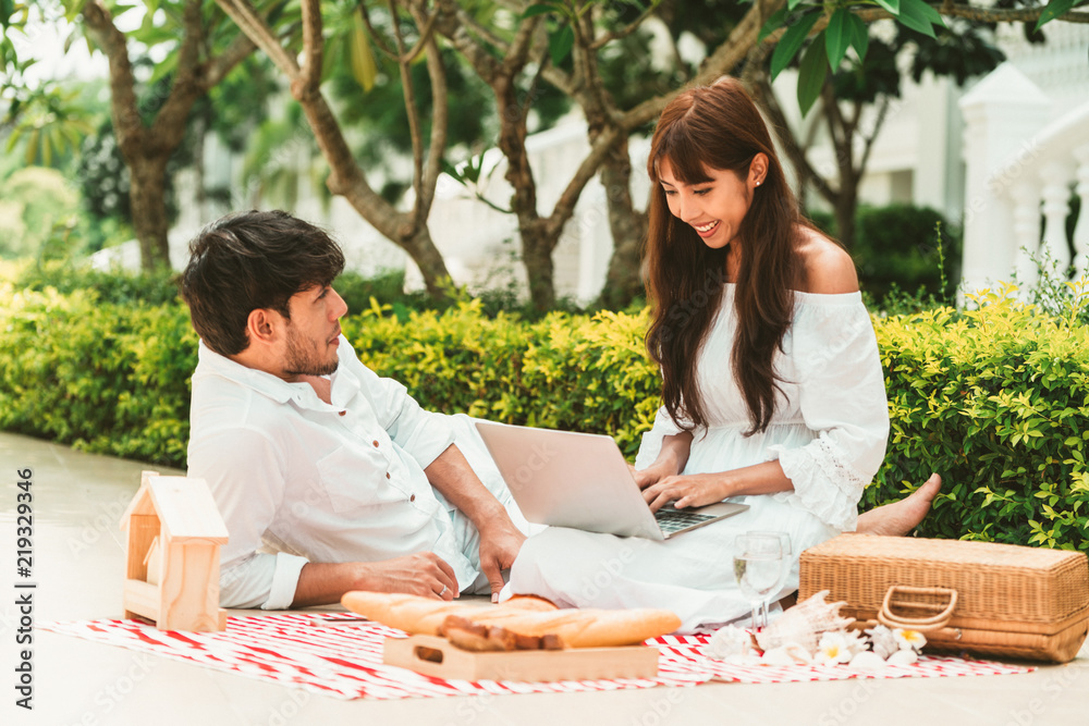 Young couple go picnic at the park in summer.