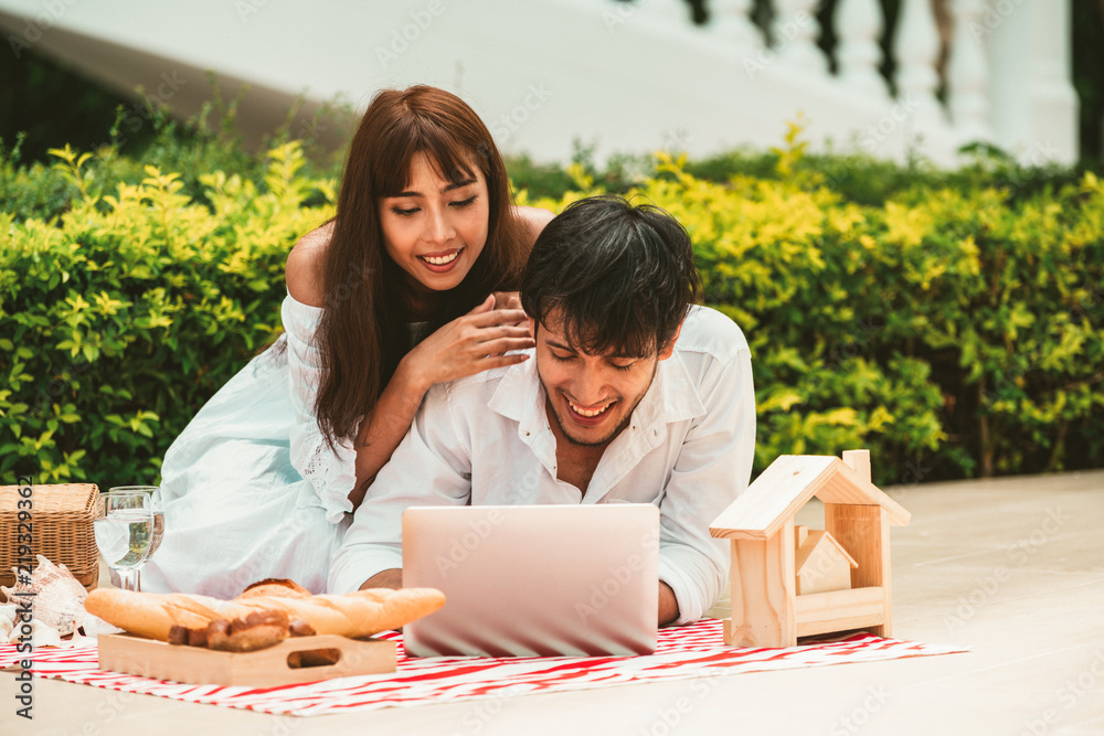 年轻夫妇夏天去公园野餐。