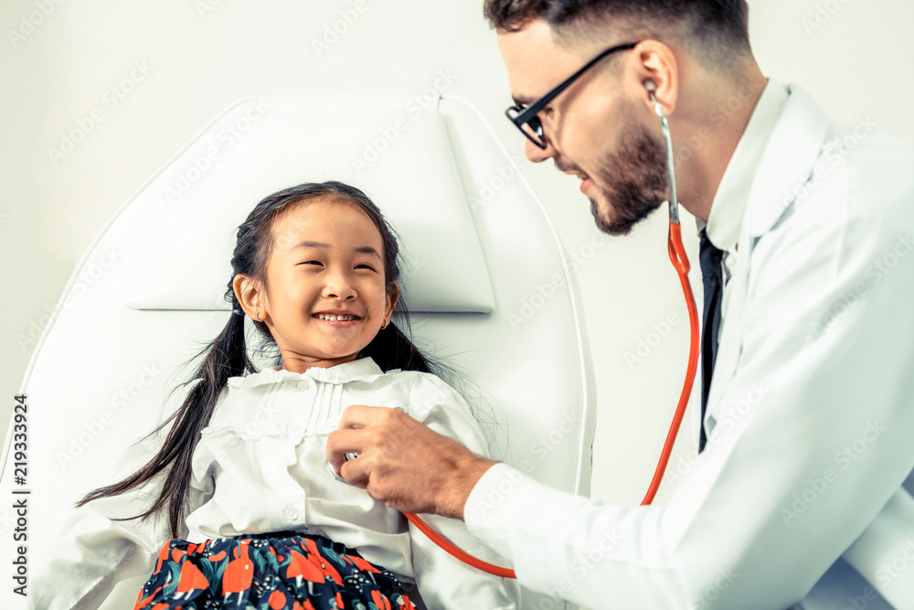 Doctor examining little happy kid in hospital.