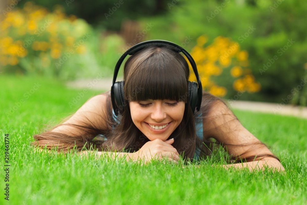 Portrait of a Young Woman Listening to Music in a Park