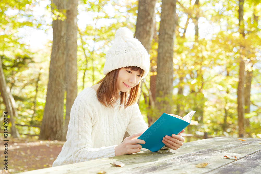 秋の紅葉の中の女性　読書