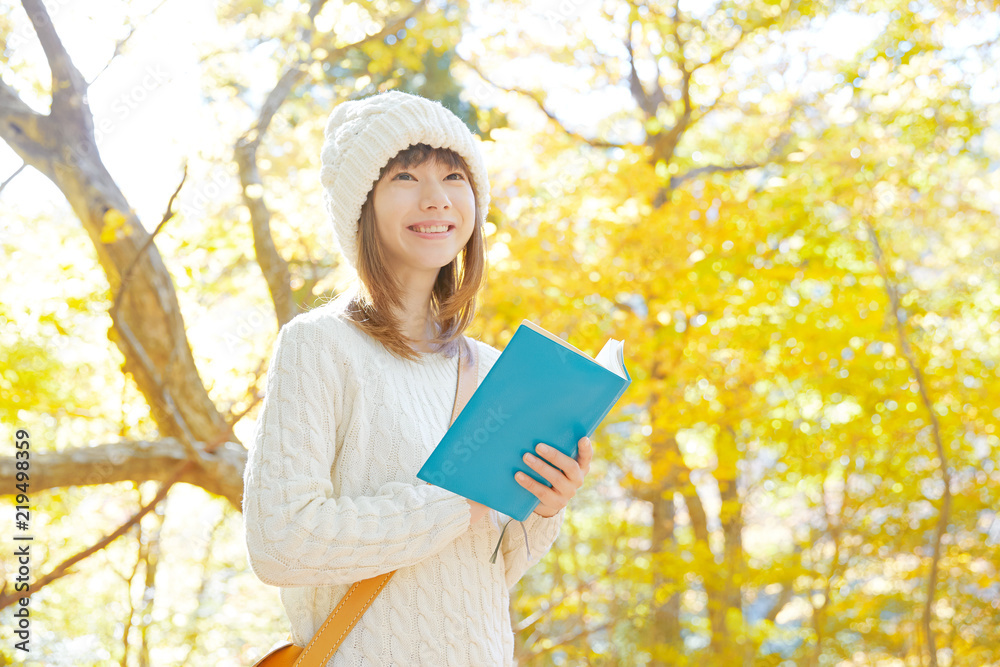 紅葉の中で読書する女性