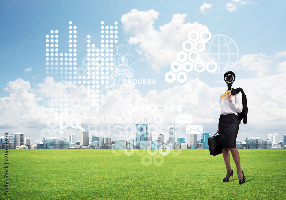 Camera headed woman standing on green grass against modern cityscape