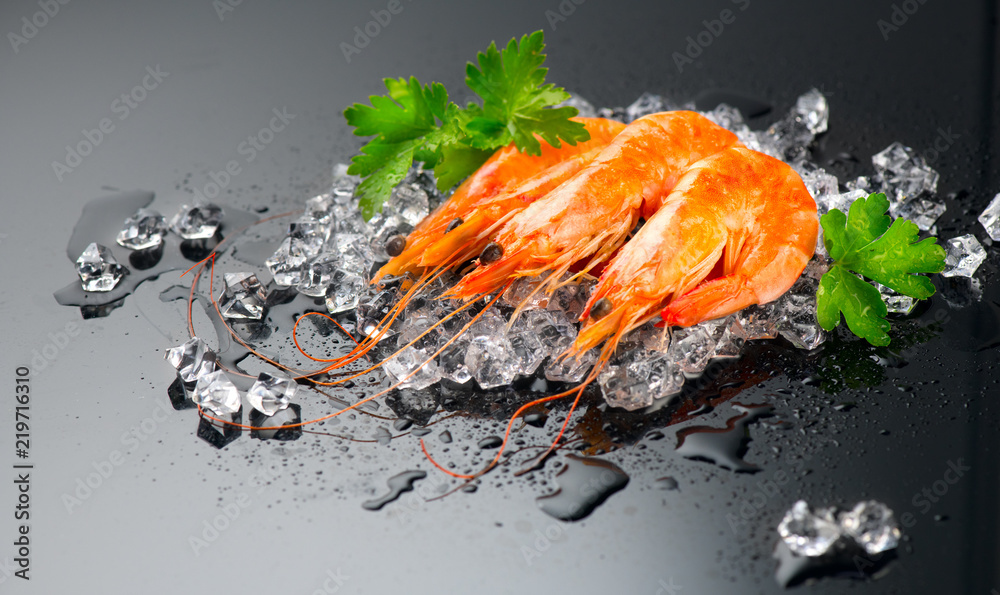 虾。黑色背景的新鲜虾。碎冰上的海鲜和香草。健康食品，烹饪