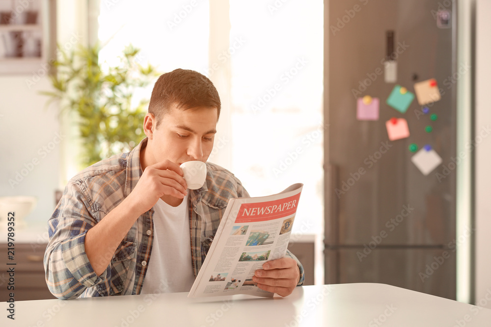 Man reading morning newspaper during breakfast at home