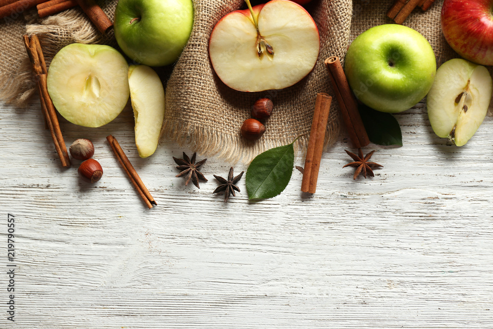 Fresh ripe apples and cinnamon on wooden background