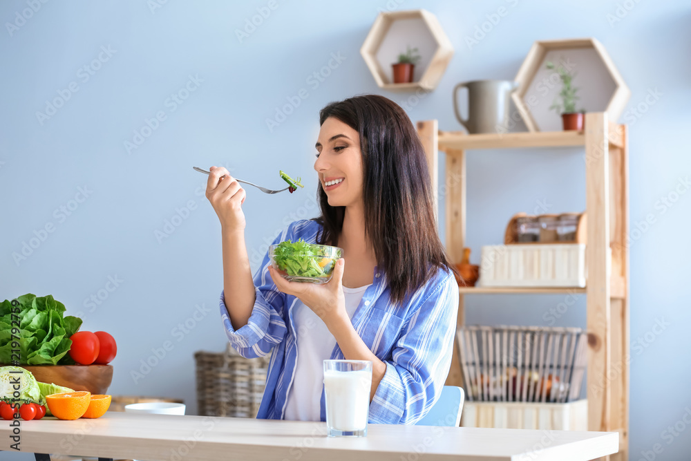 女性在室内吃健康沙拉配蔬菜