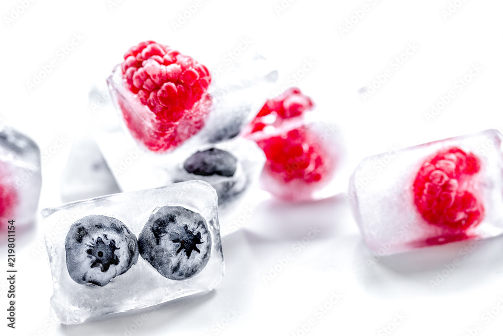 fresh blueberry and raspberry in ice on table background