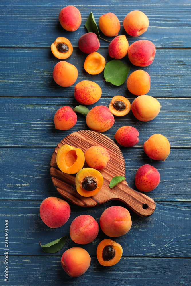 Ripe sweet apricots and board on wooden background