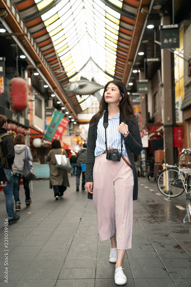 asian visitor walking in the street.