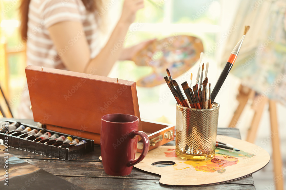 Table with brushes and paints in artists workshop