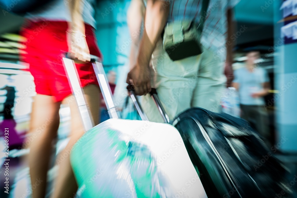 Closeup of People Walking in Airport Carrying Luggage