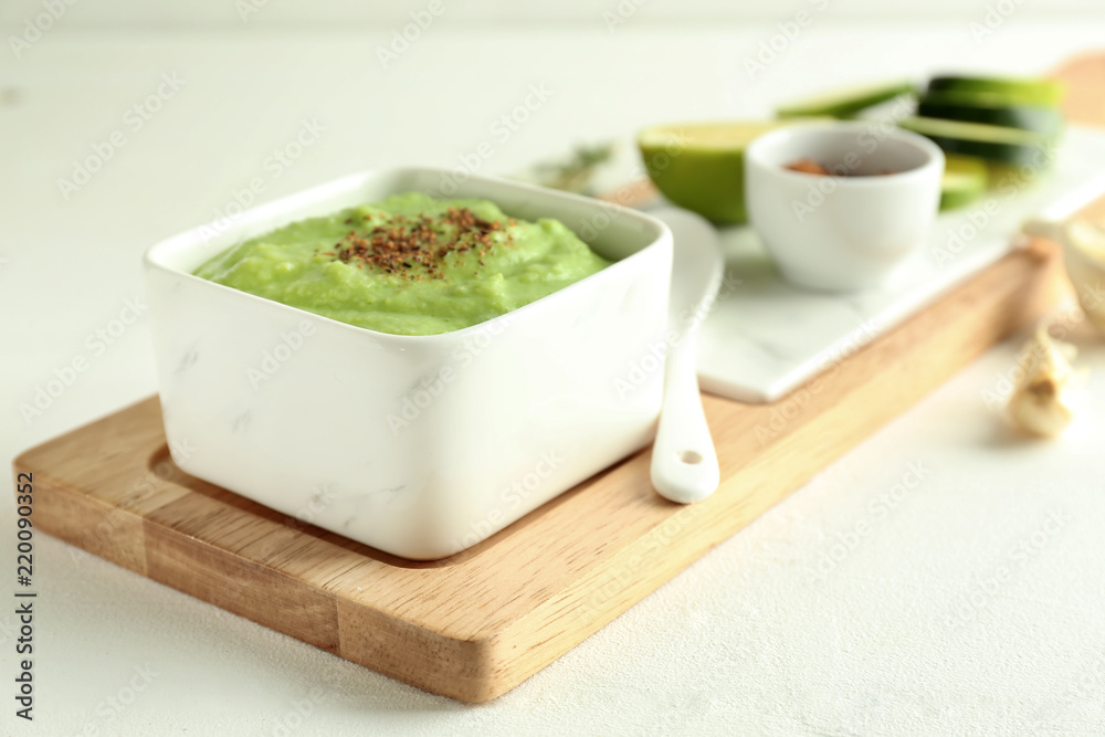 Tasty zucchini soup in bowl on light table