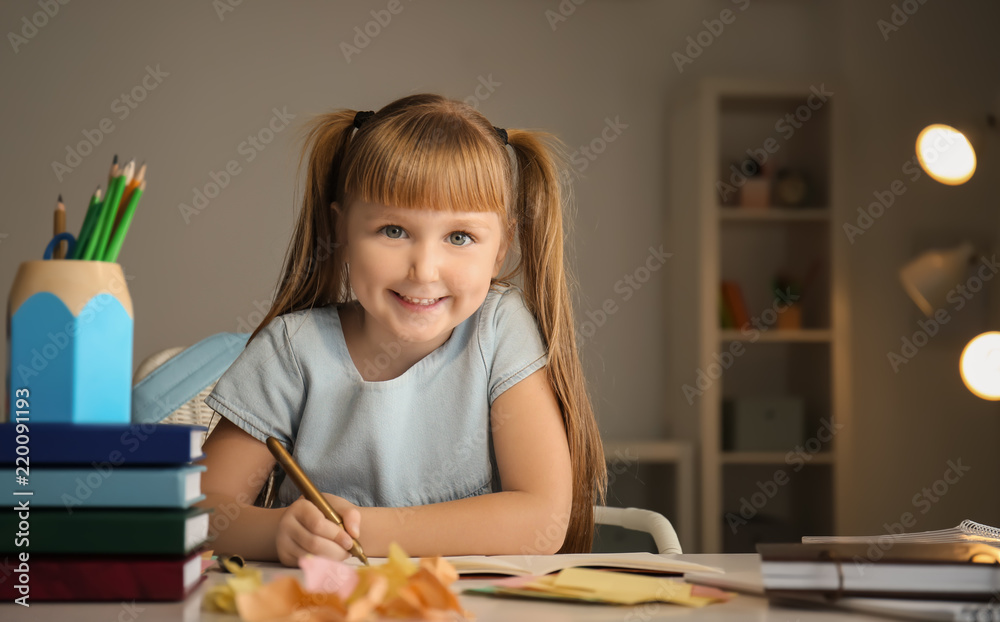 Cute little girl doing her lessons at home