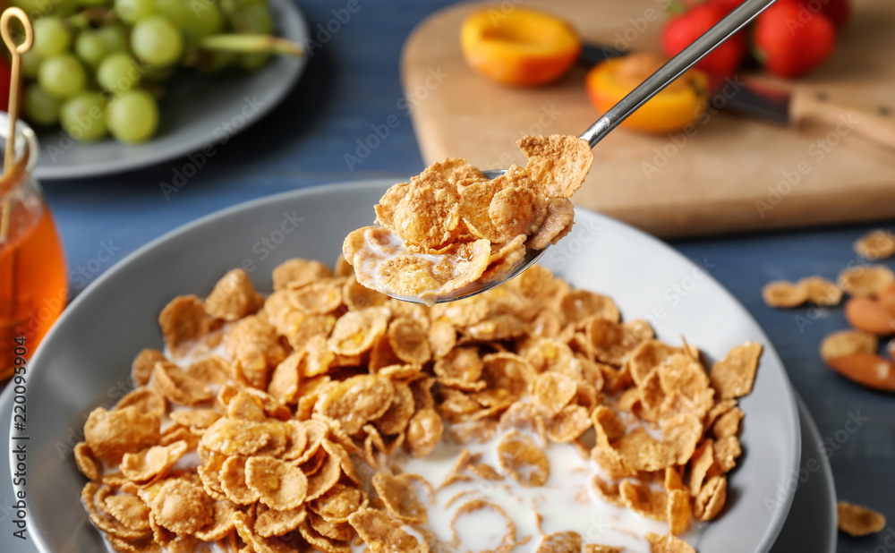 Eating of tasty corn flakes with milk, closeup