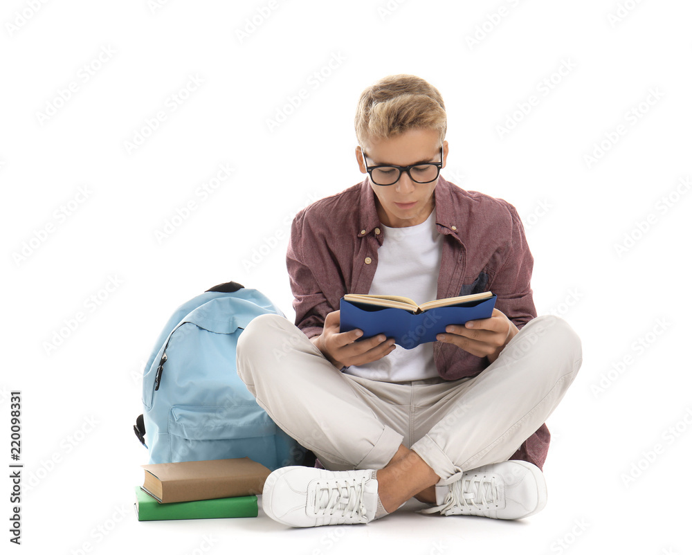 Teenage boy reading book on white background