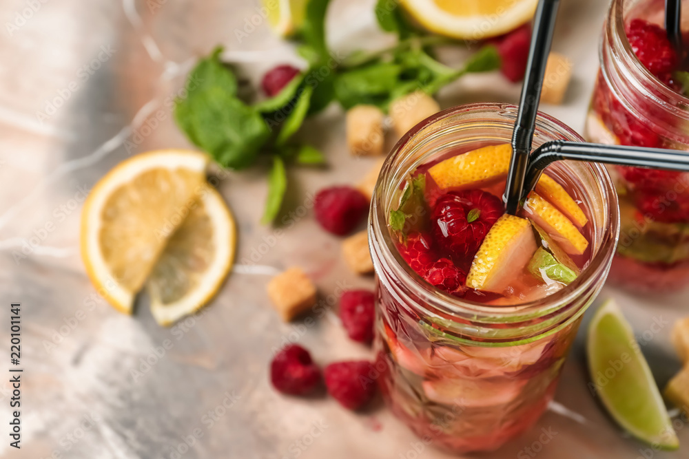 Jar of fresh raspberry mojito on table