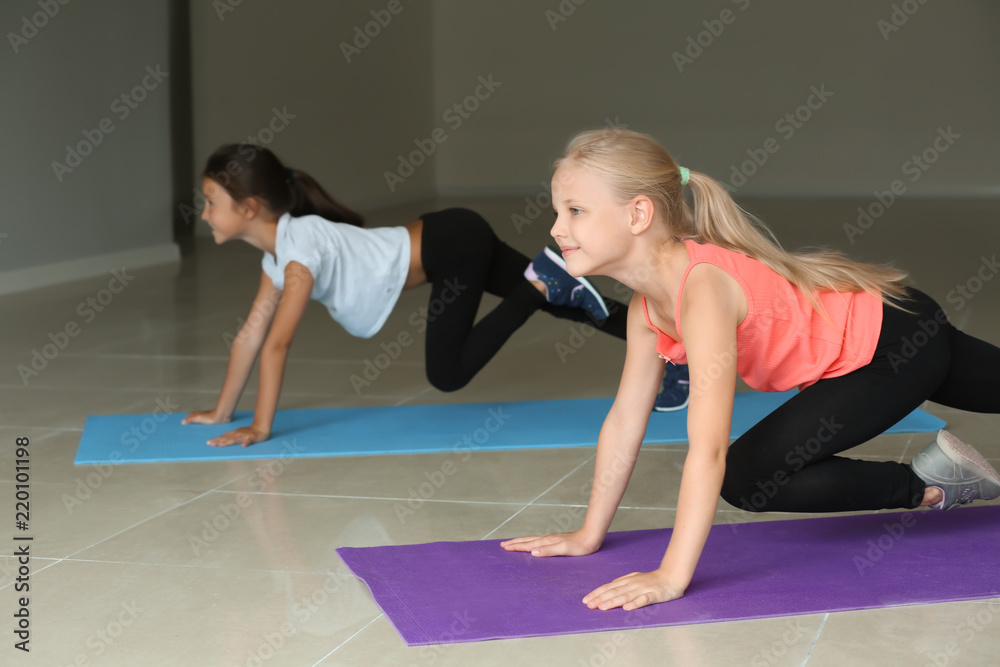 Little girls practicing yoga indoors