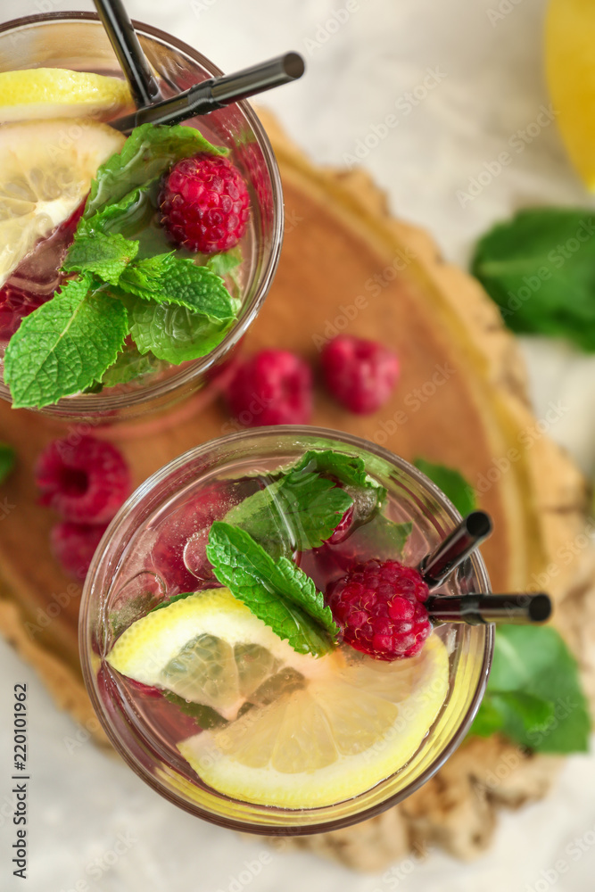 Glasses of fresh raspberry mojito on board