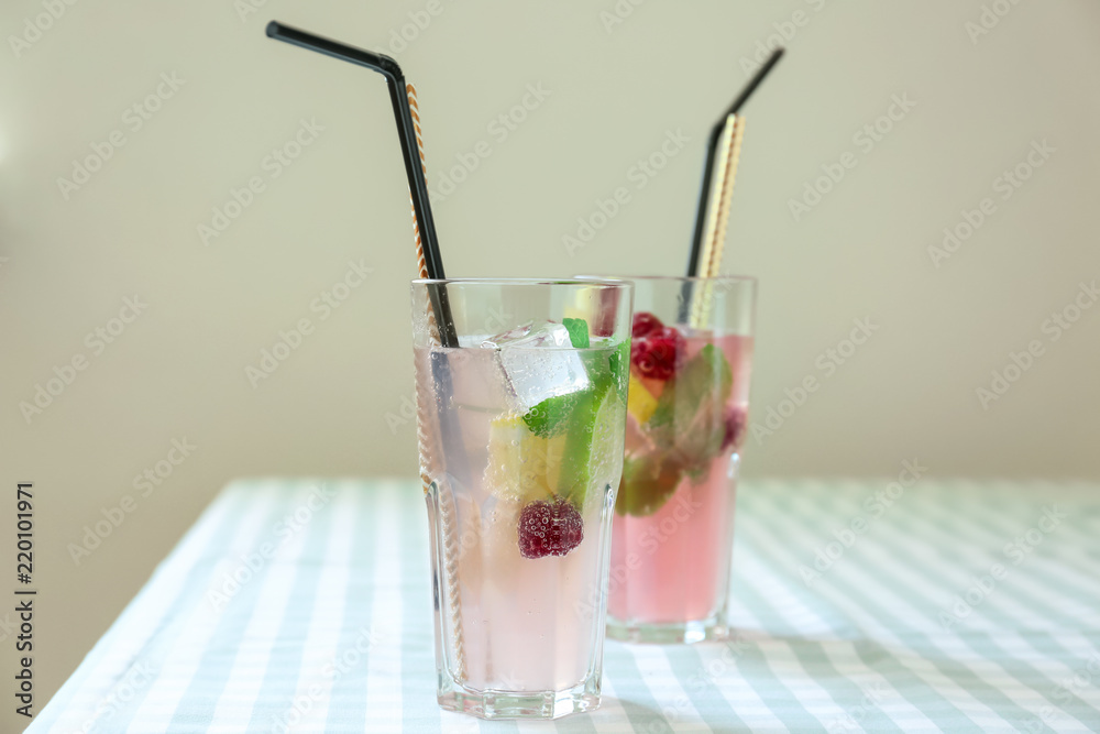 Glasses of fresh raspberry mojito on table