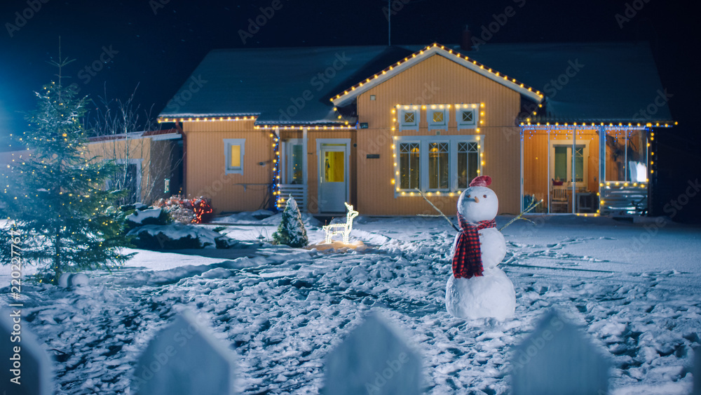 圣诞夜用花环装饰的Idyllic House的照片，雪人和圣诞树支架