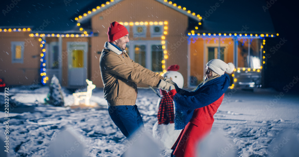 美丽的年轻情侣在他们的Idyllic House后院跳舞和旋转，而雪落Romanti