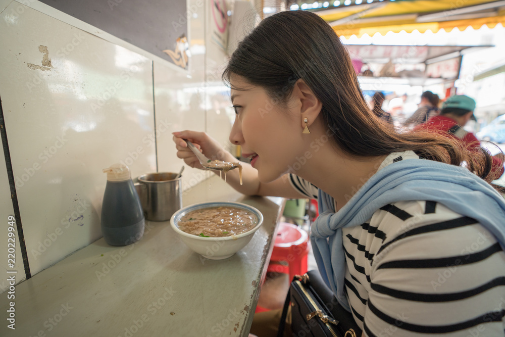 woman eating food in traditioanl old street.