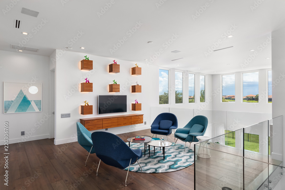 modern white and wood landing with glass staircase and blue green chairs