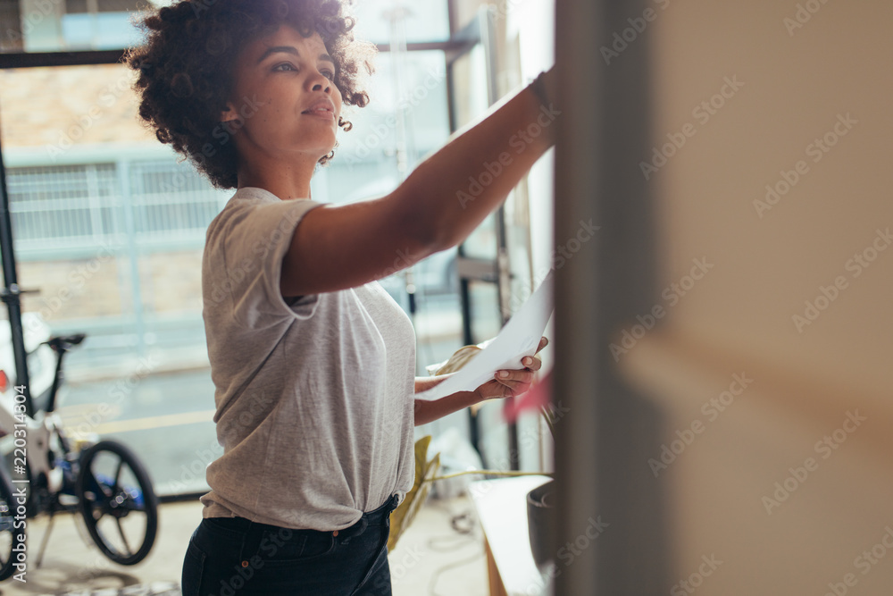 Woman writing project plan on white board