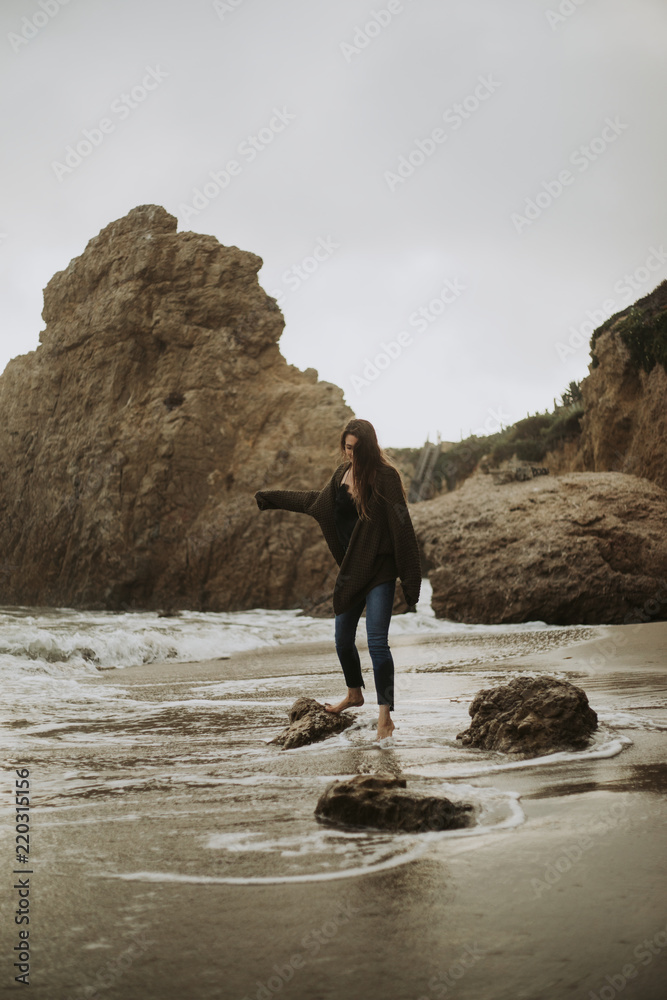 站在海滩岩石上的女人