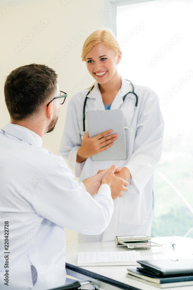 Doctor at hospital shakes hand with another doctor