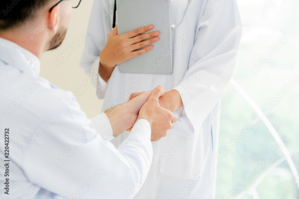 Doctor at hospital shakes hand with another doctor