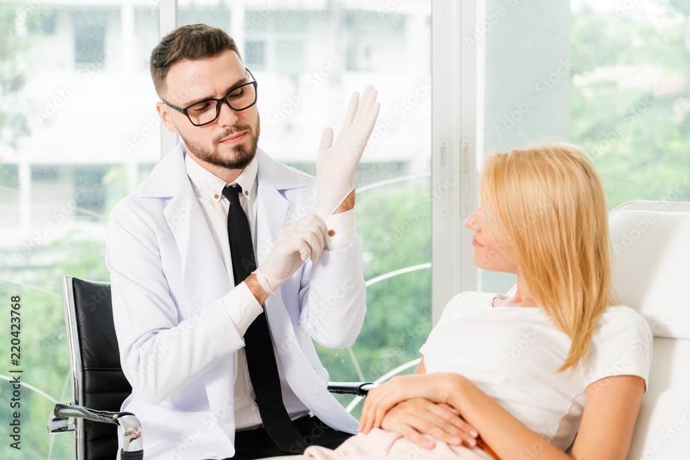 Young dentist talks with patient in dental clinic.