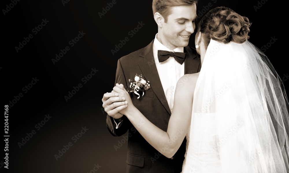 Bride and groom dancing on background