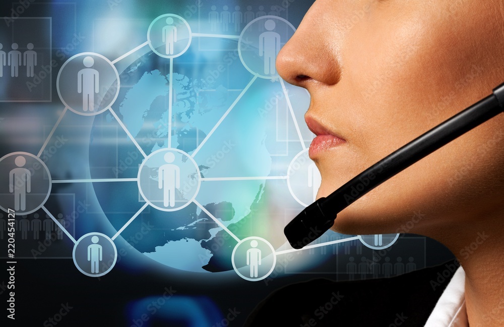 Young female call center worker on blurred technology background