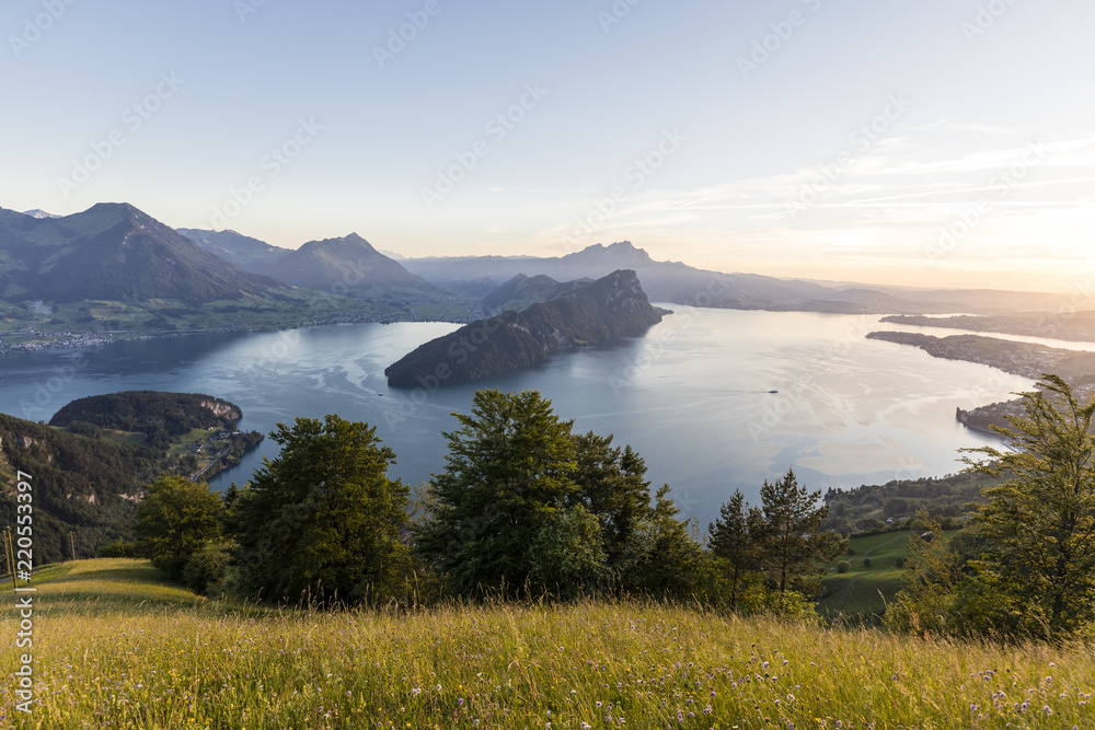 日落在卢塞恩湖上，有比尔根斯托克和皮拉图斯山，前景是草