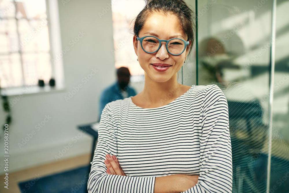 站在明亮的办公室里微笑的年轻亚洲女商人