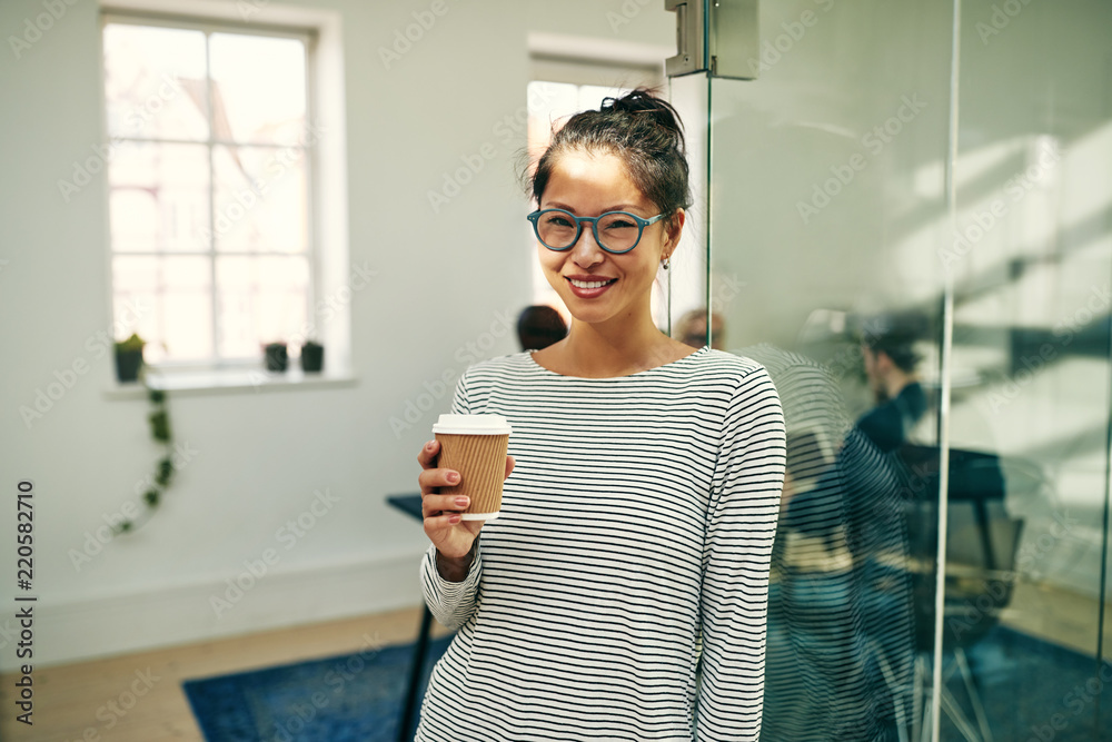 微笑的年轻亚洲女商人在休息时喝咖啡