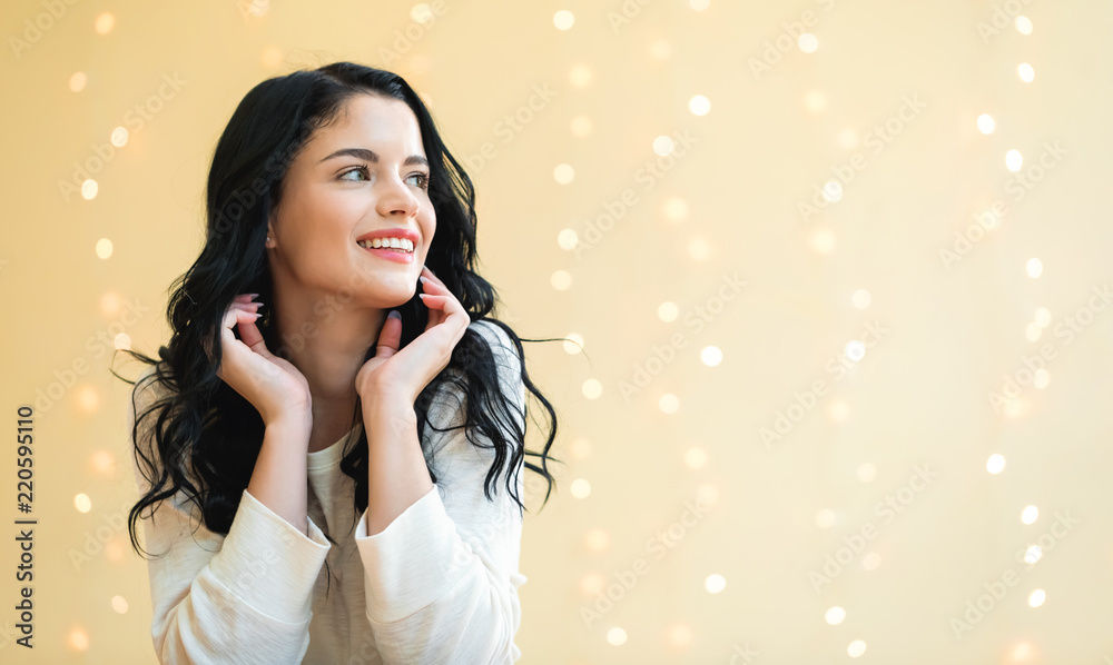 Happy young woman on a shiny lights background