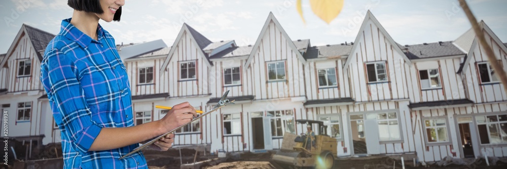 Composite image of female architect writing on clipboard against