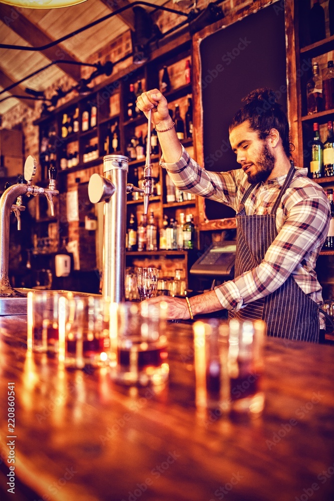 Waiter using beer tap at counter