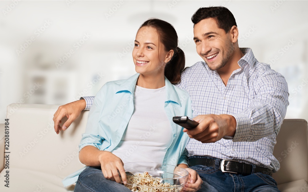 Young couple watching TV at home