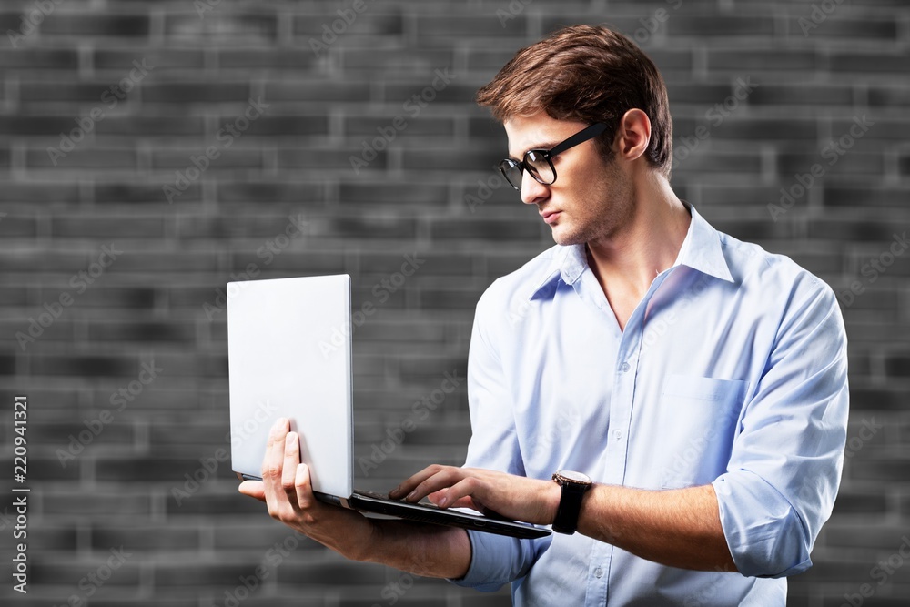 Male hands holding and using laptop