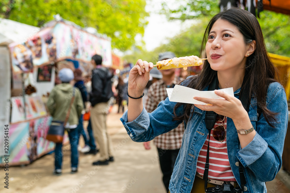 gilr eating street food and looking enjoyable