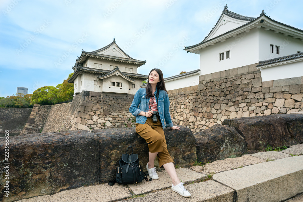 女孩坐在石桥上拿着相机