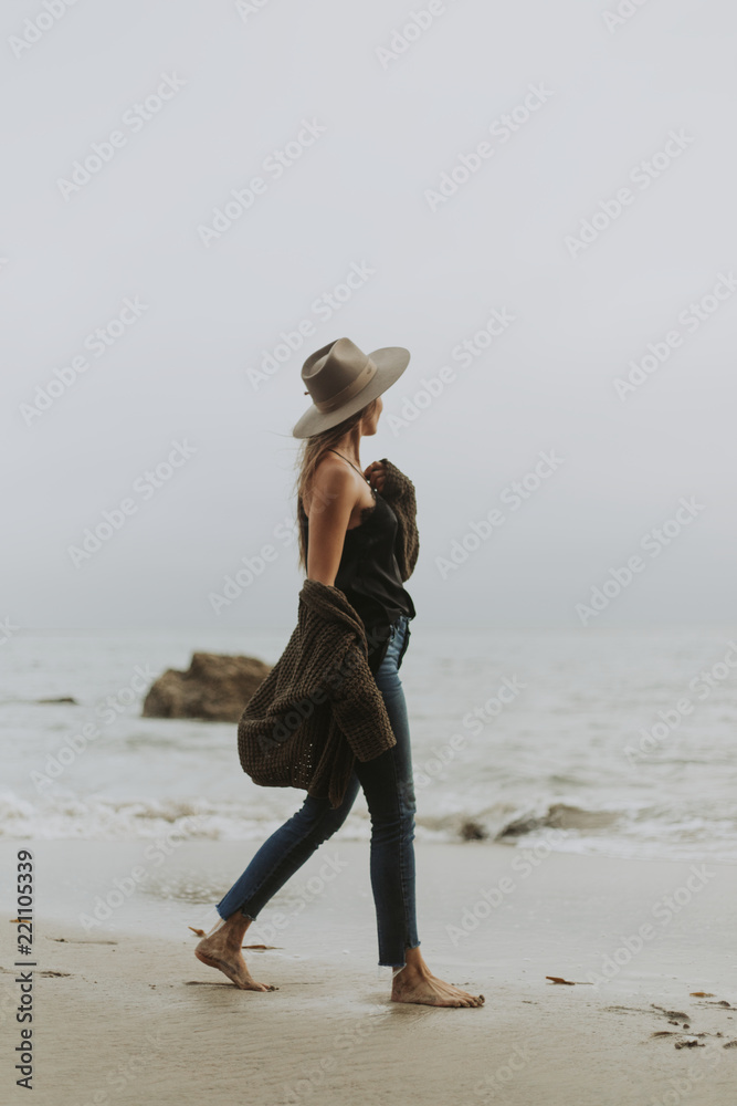 Woman walking barefoot at the beach