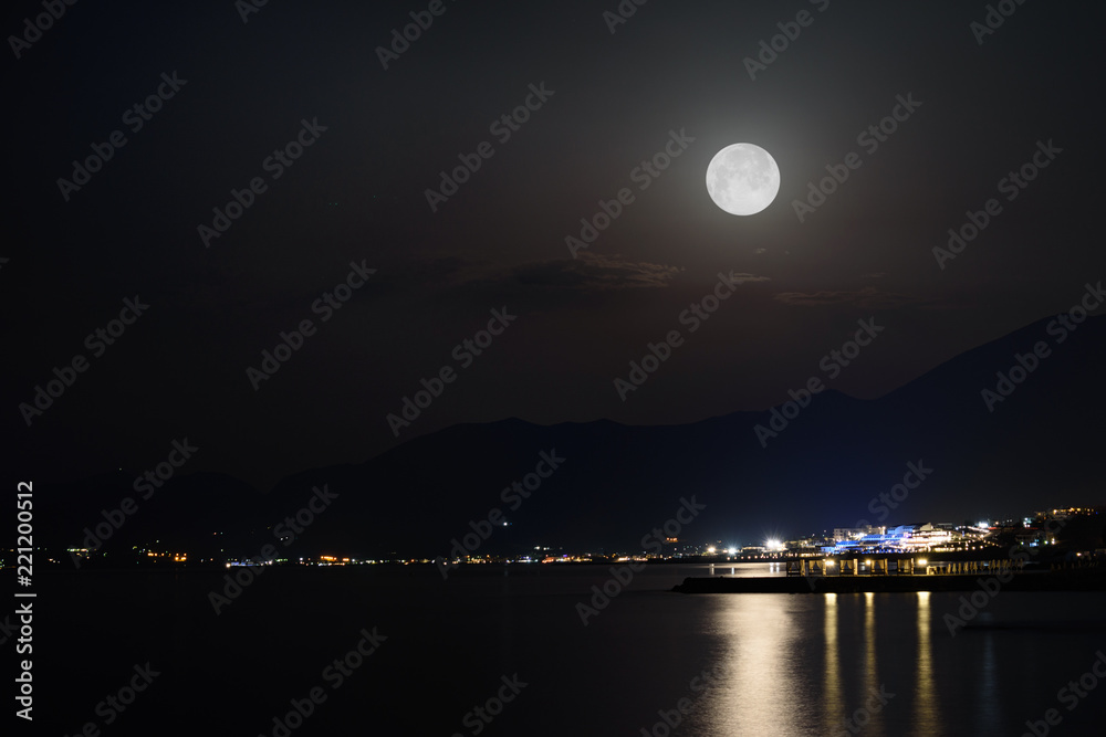 天空中有满月的城市夜景。